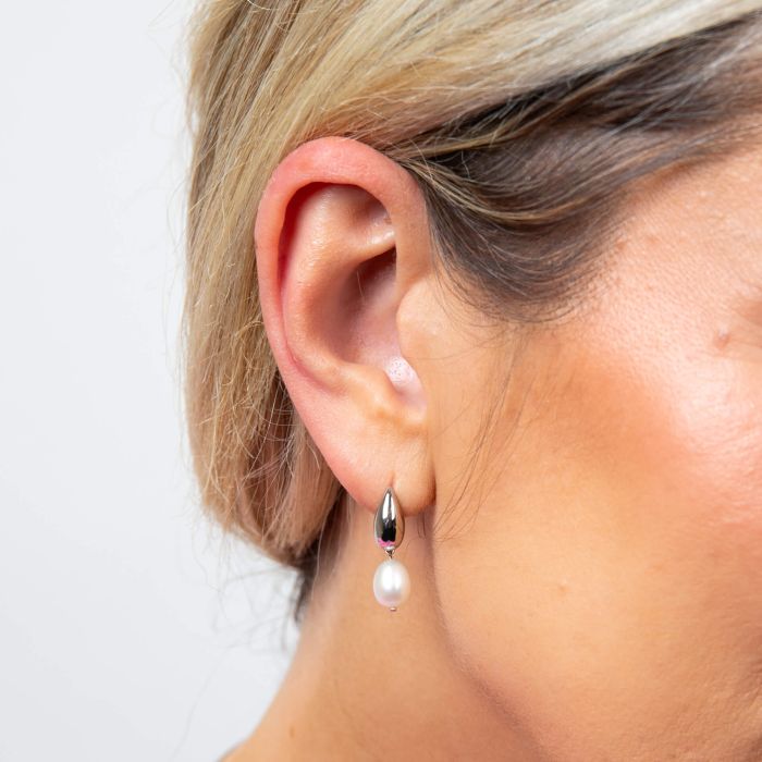 Model wearing Fiorelli Droplet Stud Earrings with Pearl e6503, featuring a classic droplet design with lustrous pearls, perfect for adding timeless elegance and sophistication to any look.