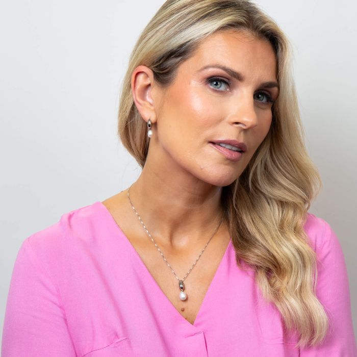 Model wearing Fiorelli Droplet Stud Earrings with Pearl e6503w paired with Fiorelli Droplet Pendant p5468w, featuring a coordinated design with lustrous pearls, perfect for adding timeless elegance and sophistication to any outfit.