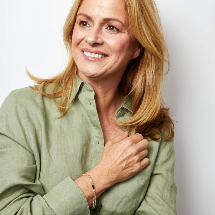 Model wearing Engravable ID Bar Double Bead Chain Bracelet in 9ct Gold, featuring a sleek double bead chain and customizable ID bar, perfect for elegant and personalized jewelry.