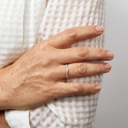 woman hand wearing diamond v shape white gold ring.