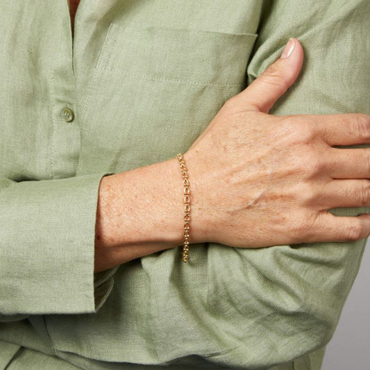 Model wearing Oval Link Bracelet in 9ct Gold, featuring interlocking oval links in polished 9ct gold, perfect for adding elegance and sophistication to any outfit.
