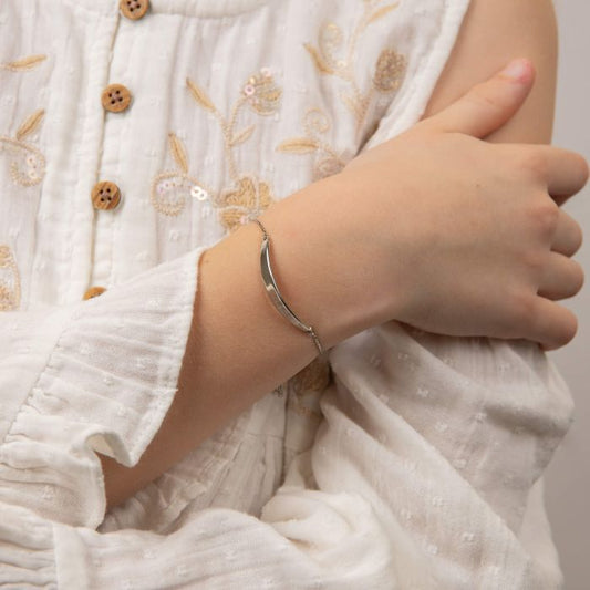 Child model wearing Pink Flower Toggle Bracelet with Diamond b5485, featuring a delicate pink flower charm with a sparkling diamond accent and an adjustable toggle closure, perfect as a charming and elegant jewelry piece for children