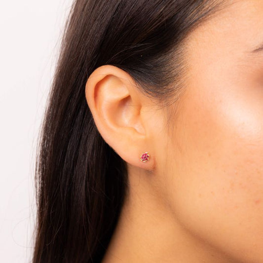 Model wearing Seven Stone Ruby Cluster Stud Earrings in 9ct Gold ge2462r, featuring a stunning cluster of seven vibrant rubies set in polished 9ct gold, perfect for adding elegance and a pop of color to any outfit.
