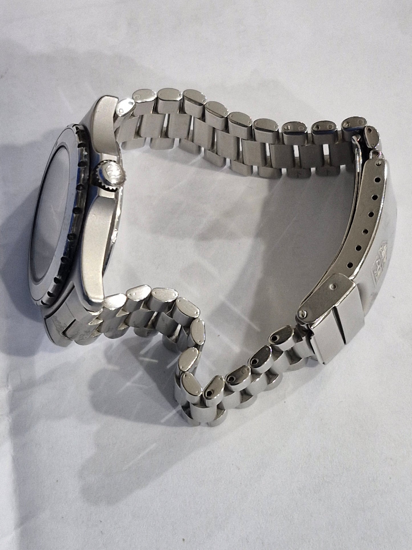 Side view of the Tag Heuer 2000 Professional quartz dive watch, showing the stainless steel case, screw-down crown, and blue bezel profile on the original oyster bracelet.