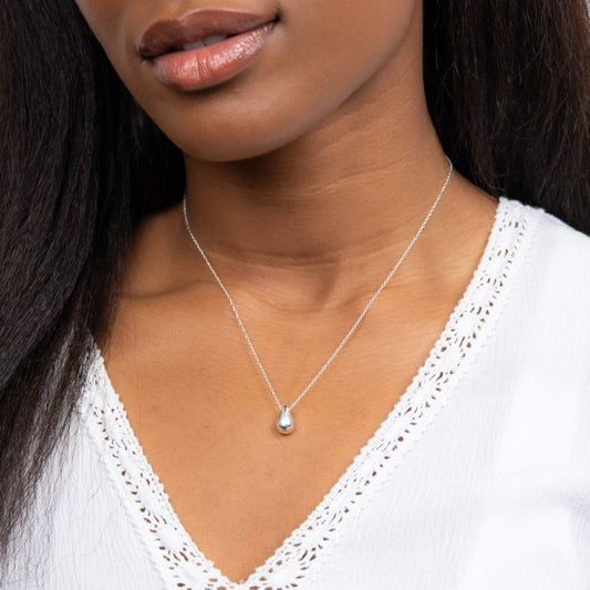 Close-up of a woman wearing Solid Teardrop Necklace silver with a pendant.