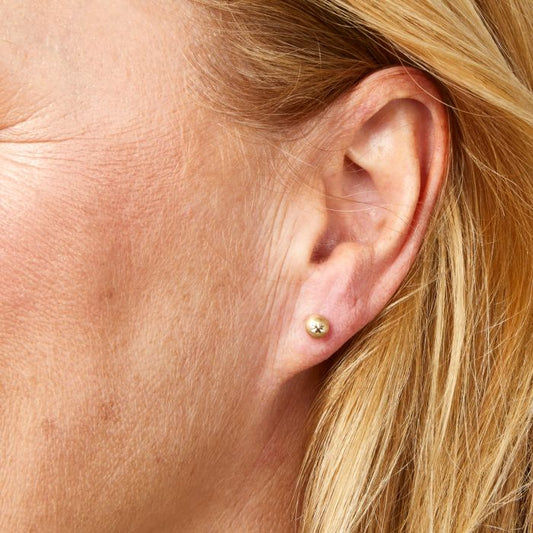 Model wearing Starburst Detail Ball Stud Earrings in 9ct Gold ge2468, featuring a polished gold ball design with intricate starburst detailing, perfect for adding elegance and subtle sparkle to any outfit.