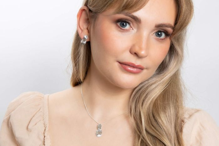 person wearing Wave Texture Silver Drop Earrings and necklace set on white background