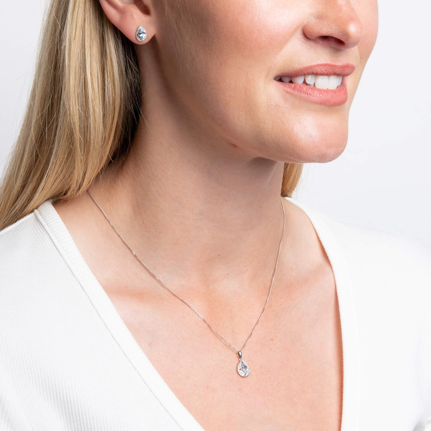 woman wearing 9ct White Gold Aquamarine & White Topaz Art Deco Pendant necklace and earrings set with white top