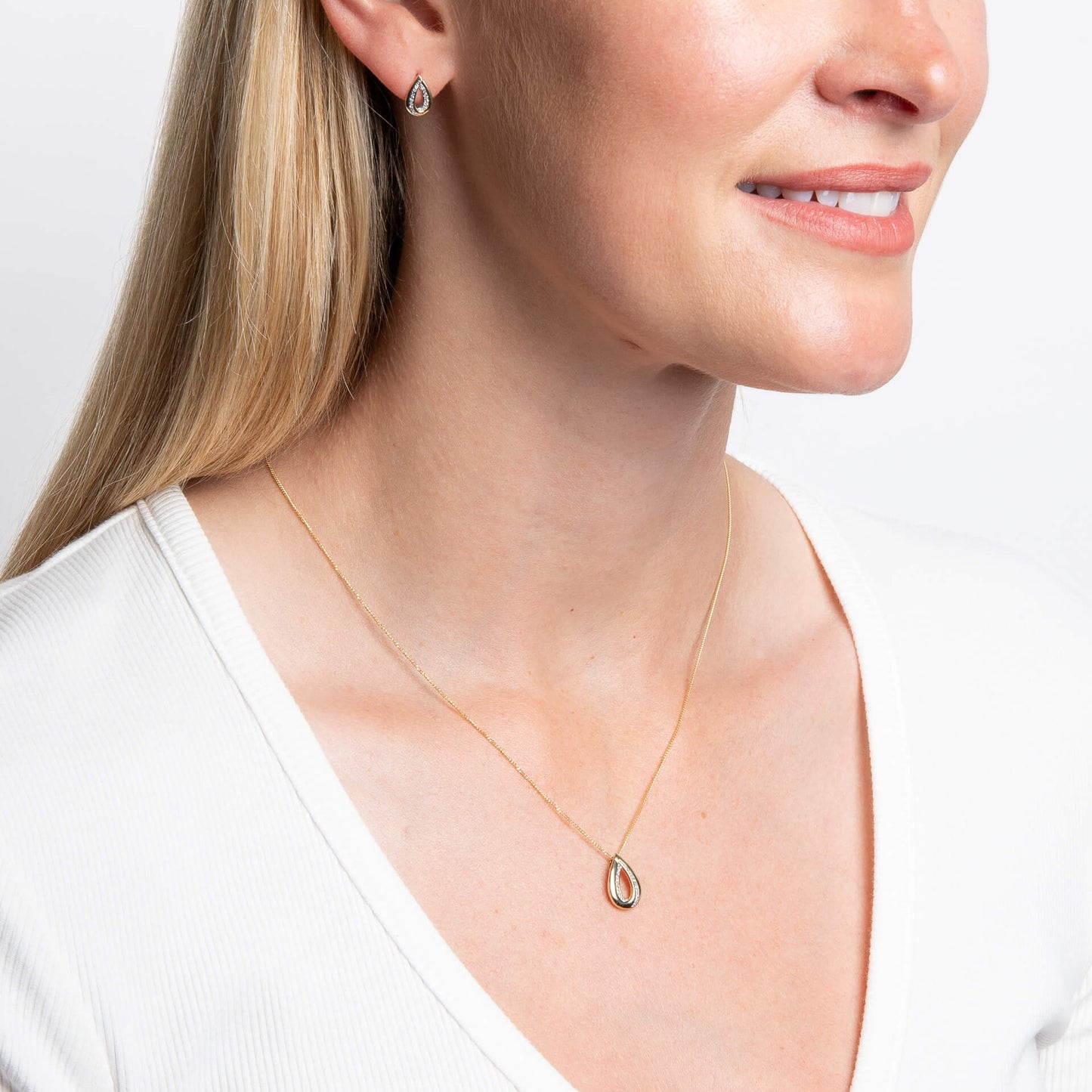 woman wearing Gold Cut Out Diamond Teardrop Pendant & Chain and earring set
