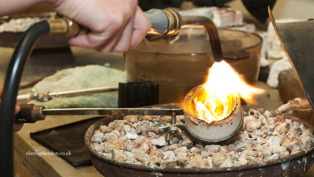 Silver jewellery being recycled to create new pieces, with molten silver being melted by a torch in the recycling process, showcasing sustainable and eco-friendly jewelry practices.