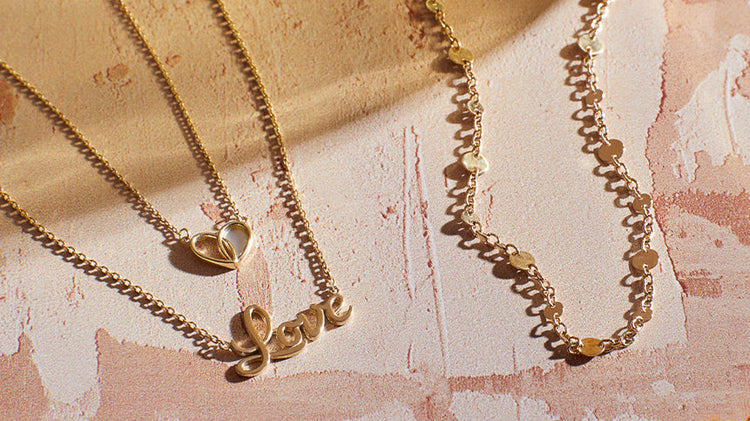 showcase of range of gold necklace on pink marble background