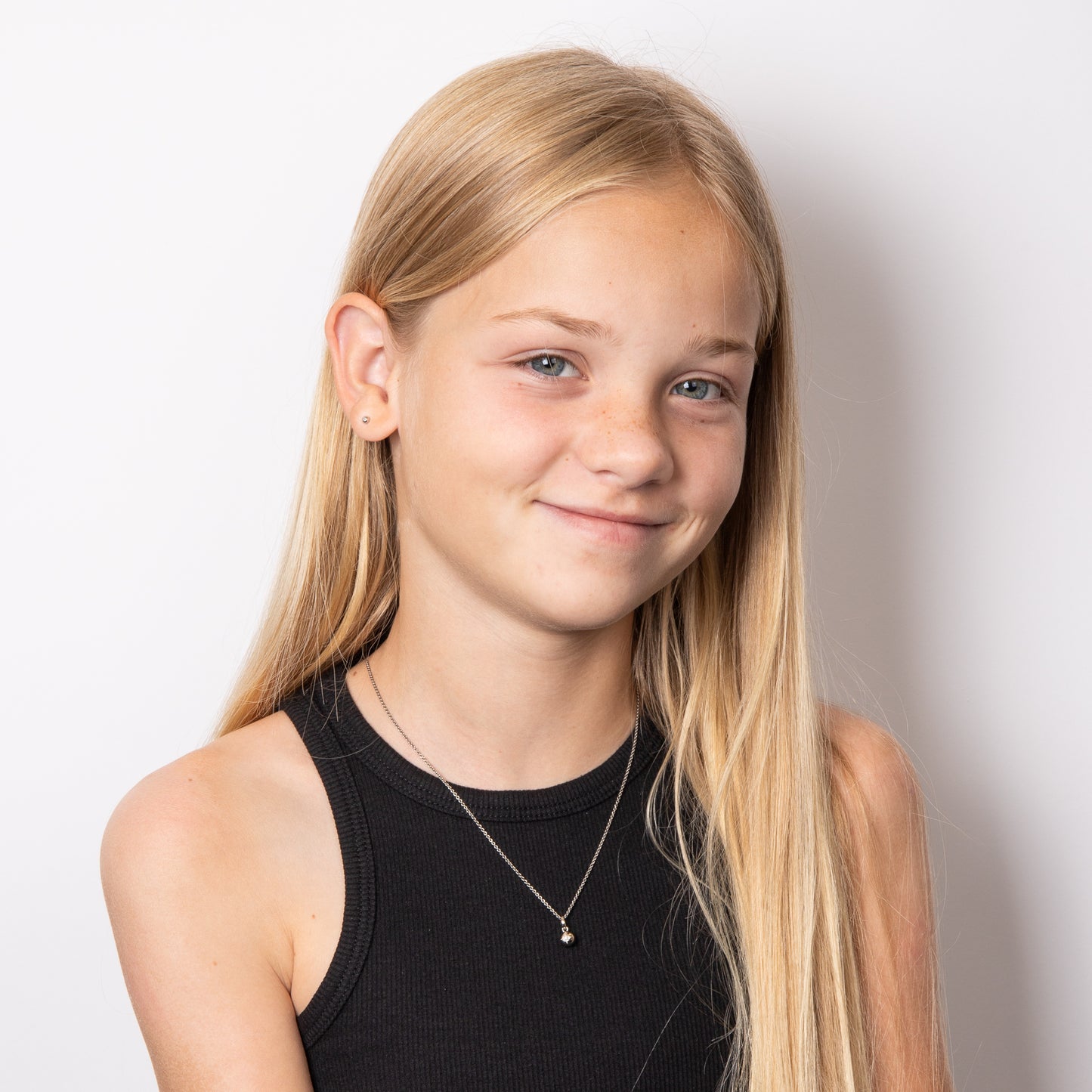 Young girl wearing A pair of Starburst Silver Stud Earrings and necklace set with Diamonds