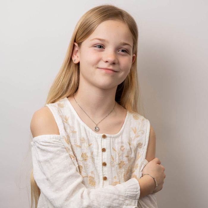 Child wearing silver teddy bear necklace and expandable bracelet bangle IMG_0020, featuring a charming teddy bear pendant and a sleek engravable bangle with a sparkling diamond accent, perfect as a timeless keepsake for babies and children.