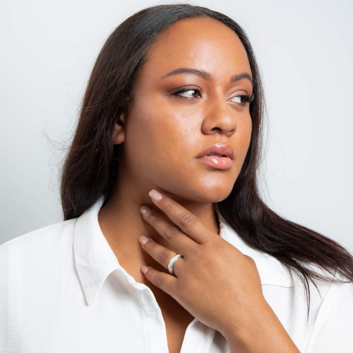 Woman wearing Cubic Zirconia Silver Spinner Ring and a white shirt with a plain background