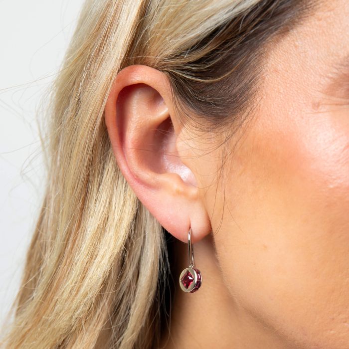 Model wearing Fiorelli Mixed Shape Fuchsia Crystal Earrings e6459p, featuring a bold and vibrant design with mixed-shaped fuchsia crystals, perfect for adding elegance and a pop of color to any outfit.