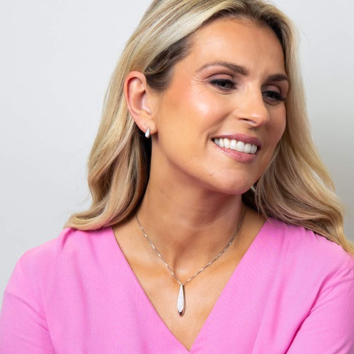 Model wearing Fiorelli Tilted Droplet Pendant p5434c paired with Tilted Droplet Earrings e6455c, featuring a sleek and modern design with sparkling cubic zirconia accents, perfect for creating an elegant and coordinated jewelry look.
