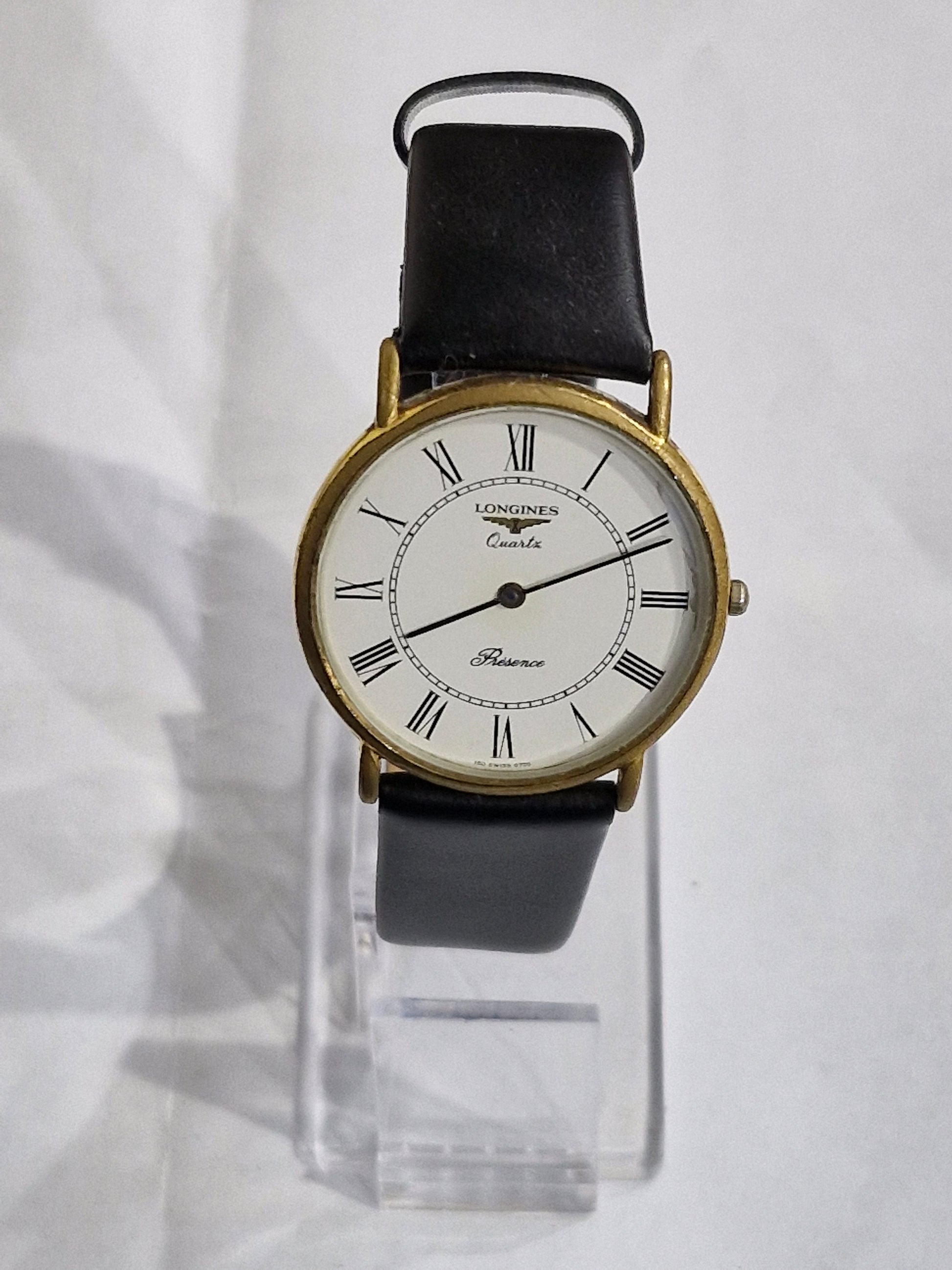 Vintage Longines Presence gold-plated watch with white Roman numeral dial and black leather strap