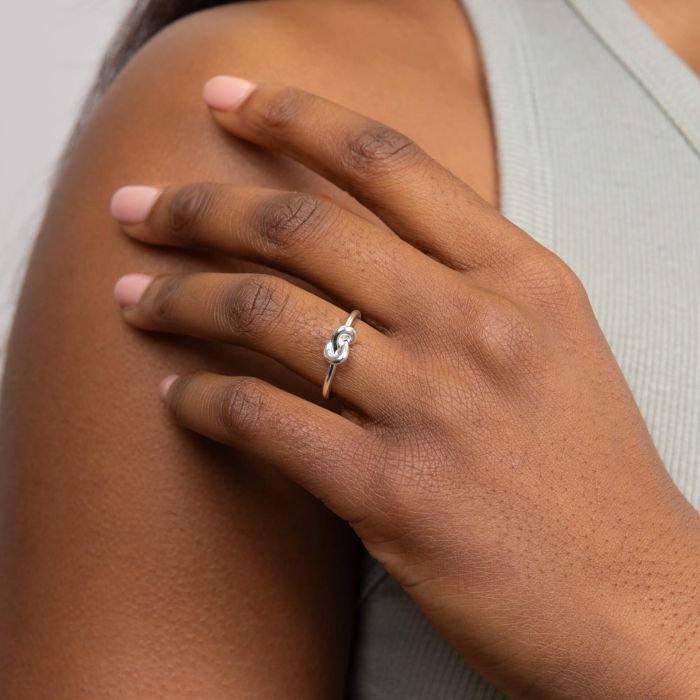 woman wearing Love Knot silver Ring on finger close up