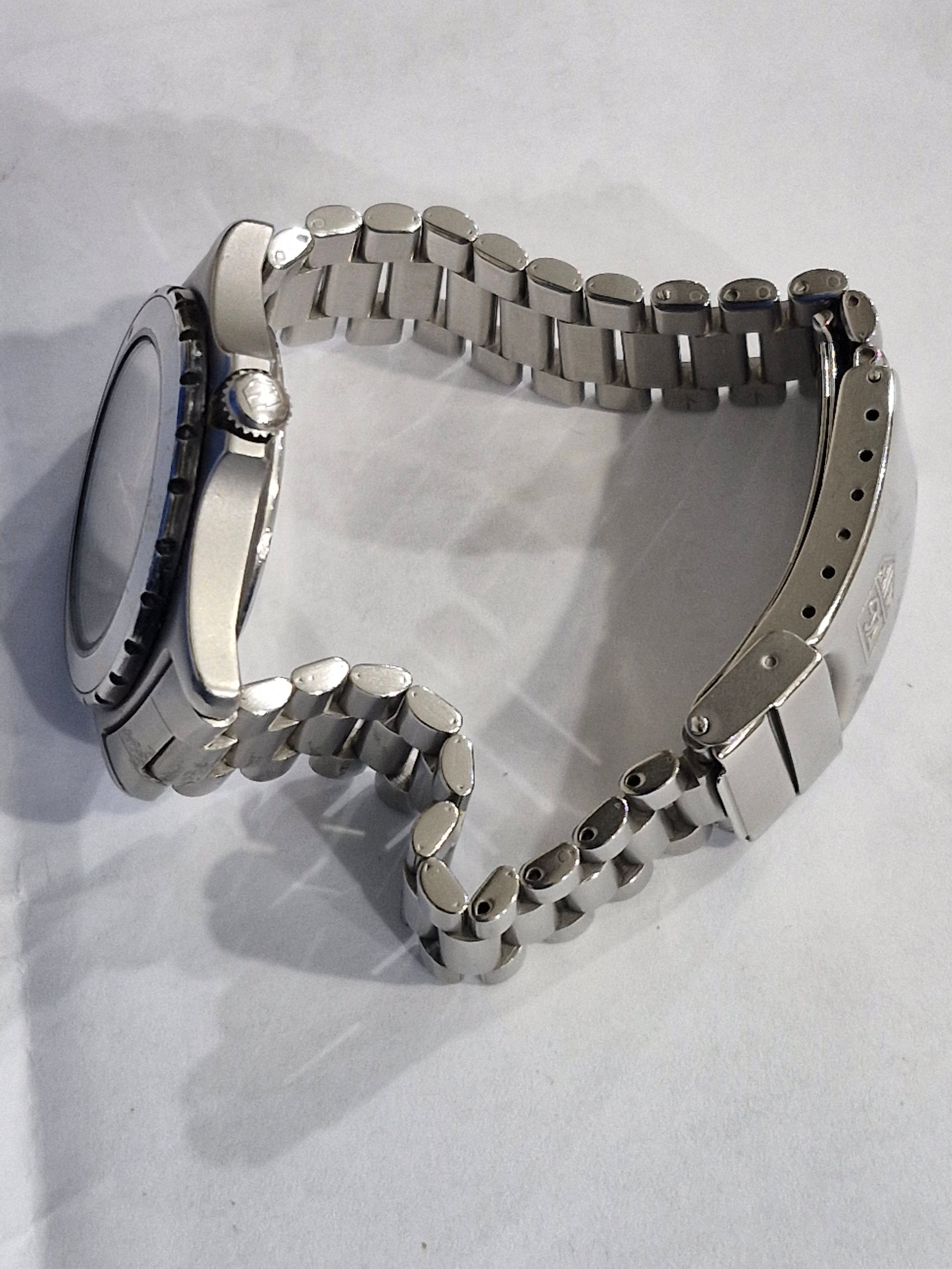 Side view of the Tag Heuer 2000 Professional quartz dive watch, showing the stainless steel case, screw-down crown, and blue bezel profile on the original oyster bracelet.