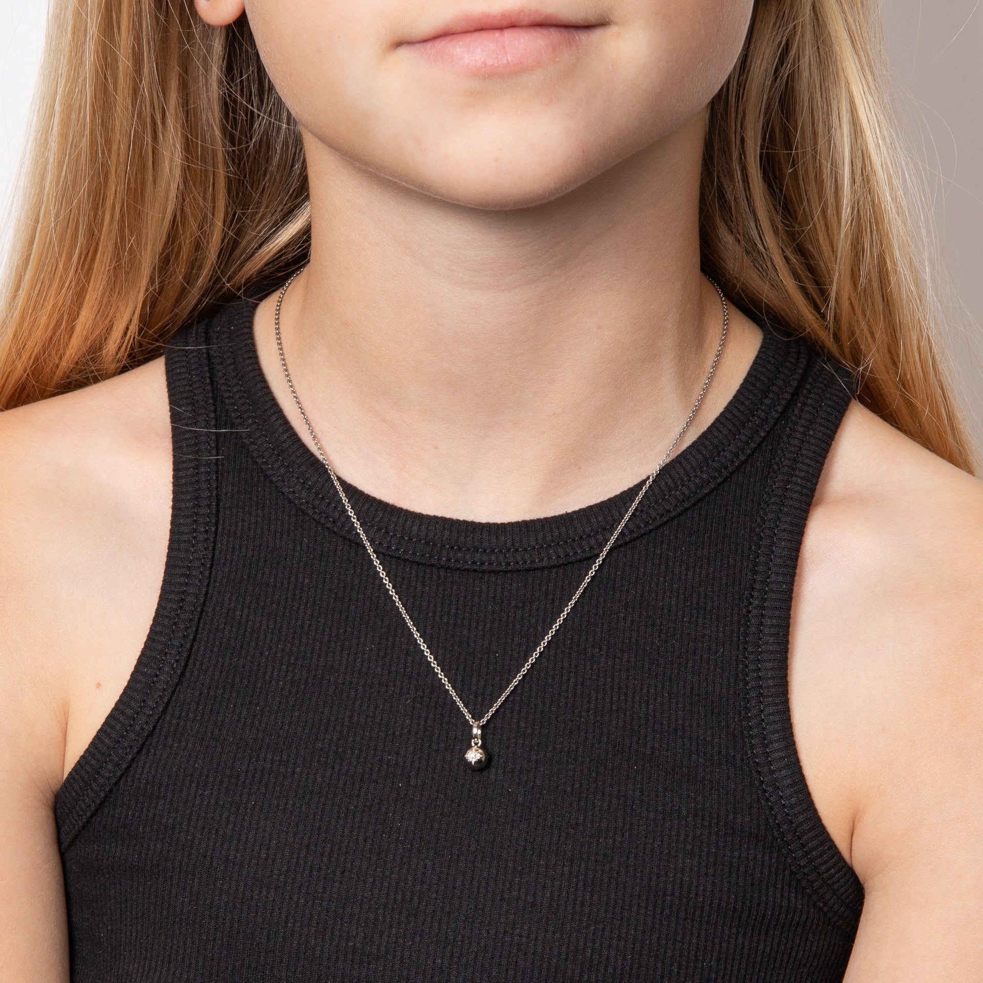 close up of Child wearing silver with diamond star sparkle pendant necklace, featuring a delicate star-shaped design crafted in polished silver with a sparkling diamond accent, perfect for adding charm and elegance to a young jewellery collection.