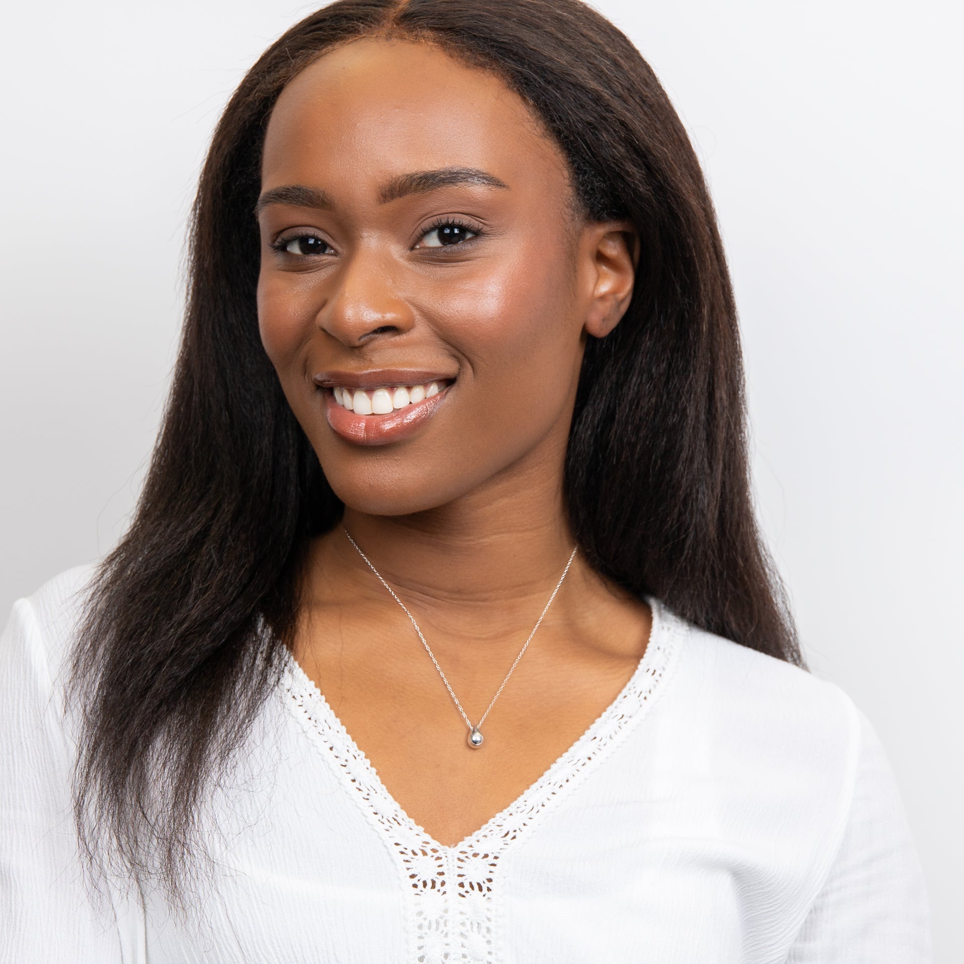 from far of a woman wearing Solid Teardrop Necklace silver with a pendant.
