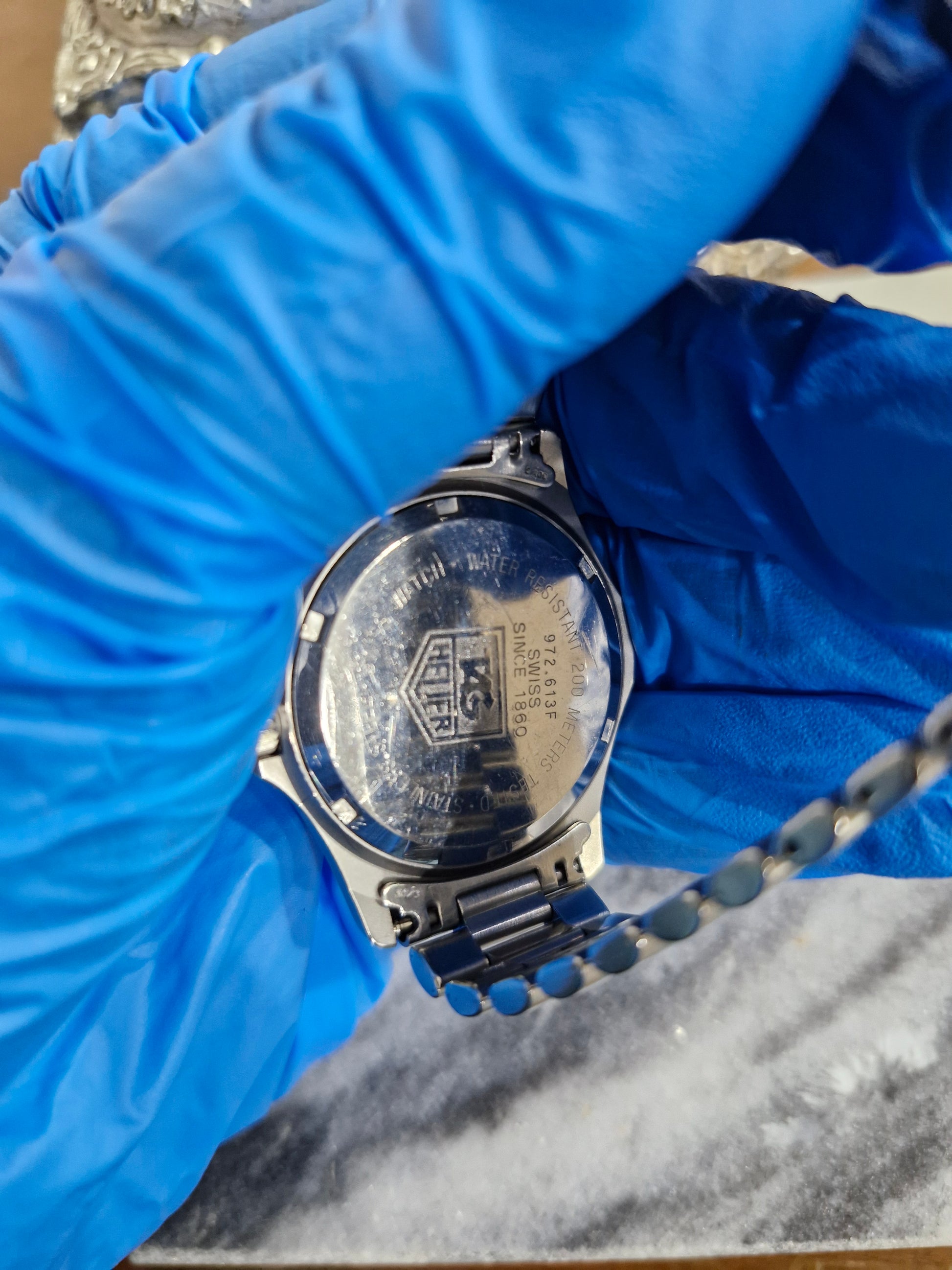 Case back of a 1990s Tag Heuer 2000 Professional quartz dive watch, showing the stainless steel screw-down back with engraved Tag Heuer logo and model markings.