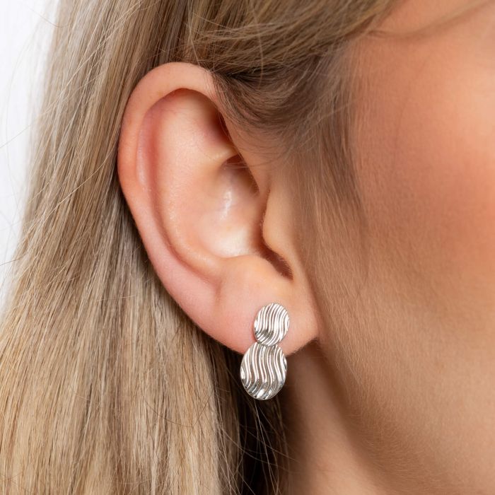 persons ear close up wearing Wave Texture Silver Drop Earrings