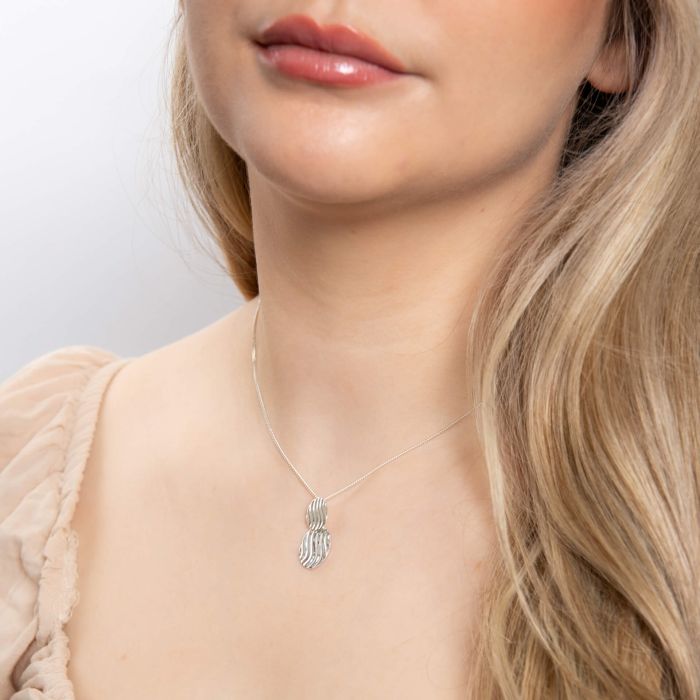 person earing Wave Texture Silver Drop Pendant necklace on white background 