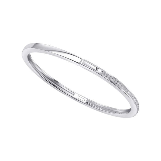 Silver bangle bracelet with small row of shimmering cubic zirconia on a white background