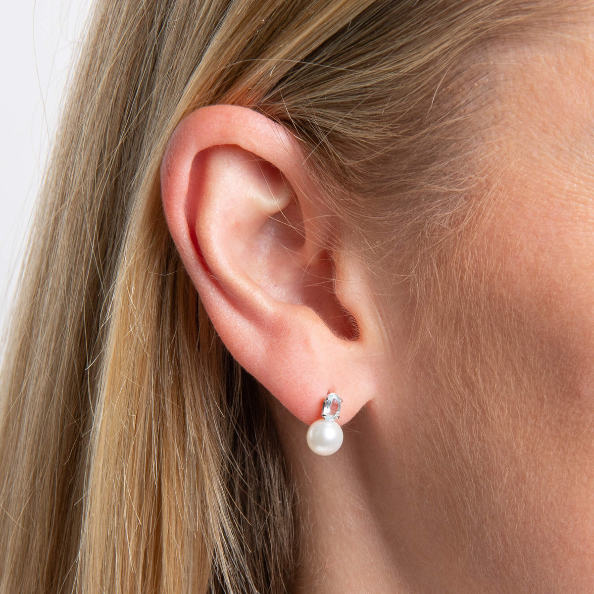 close up ear wearing 9ct Gold Freshwater Pearl & Sky Blue Topaz earring. 