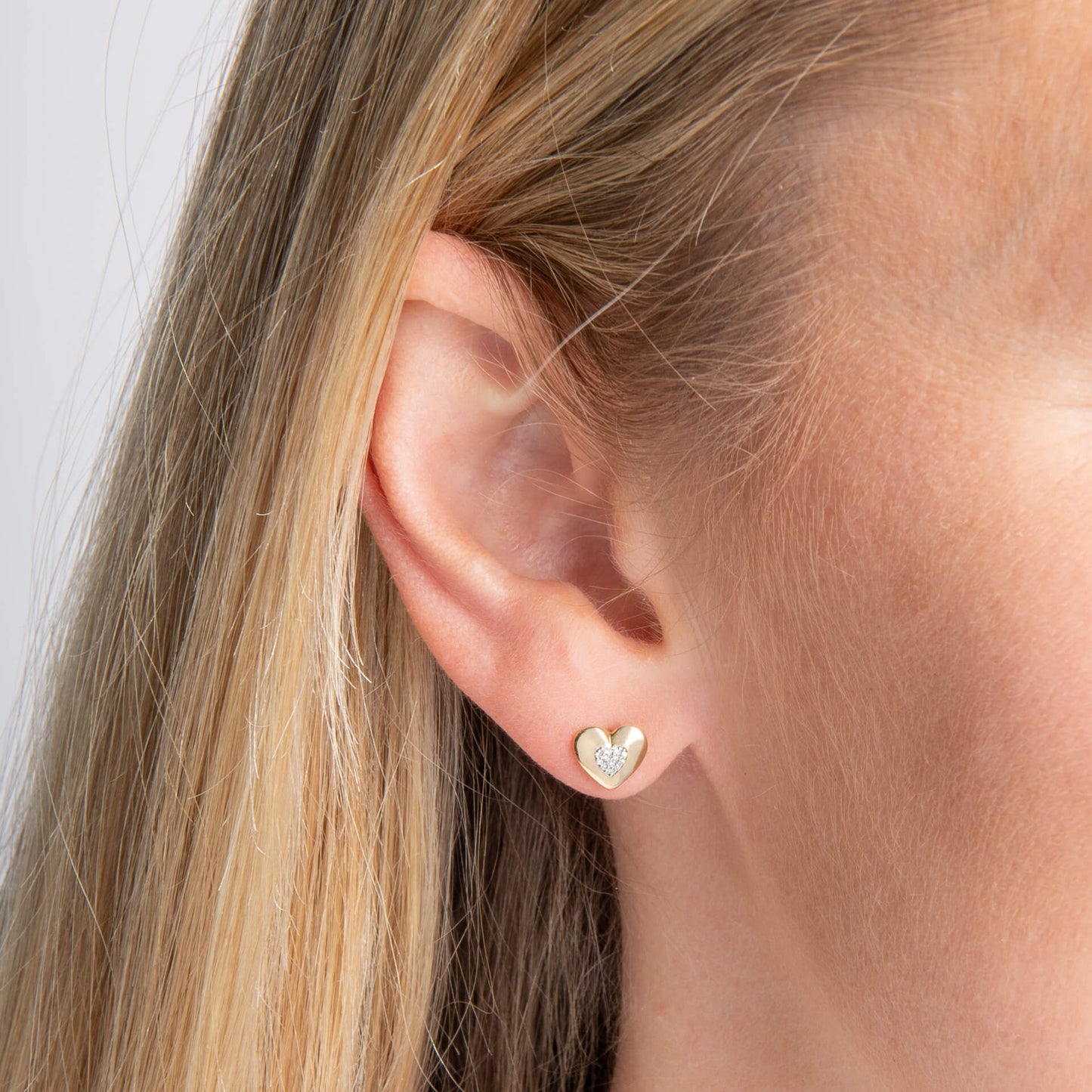 close up ear wearing Gold Pavé Diamond Heart stud earring 