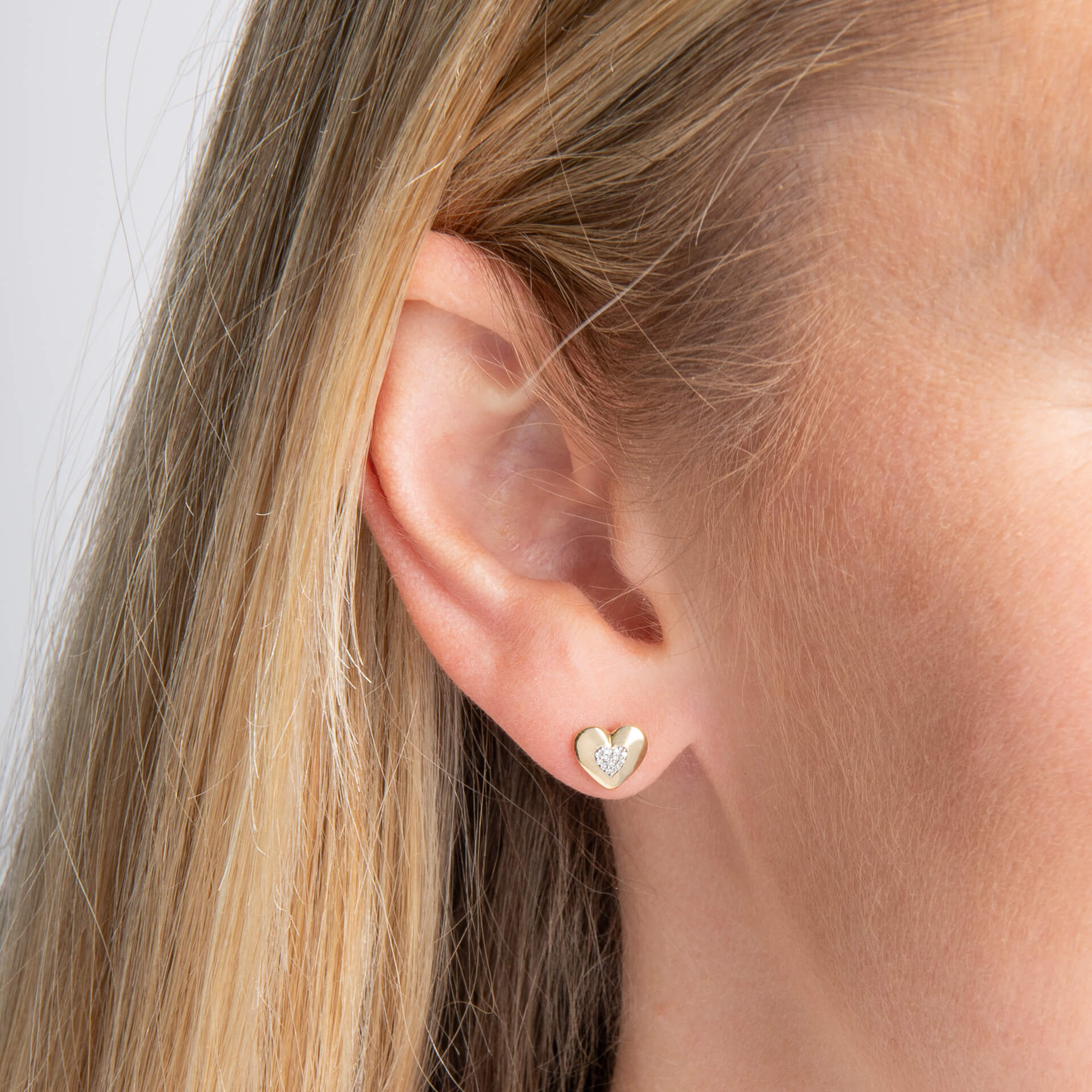 close up ear wearing Gold Pavé Diamond Heart stud earring 