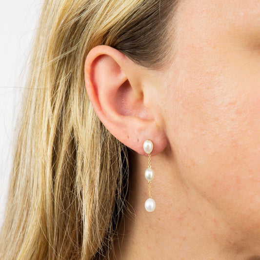 close up of ear wearing Freshwater Pearl Tier Drop Earrings on white background