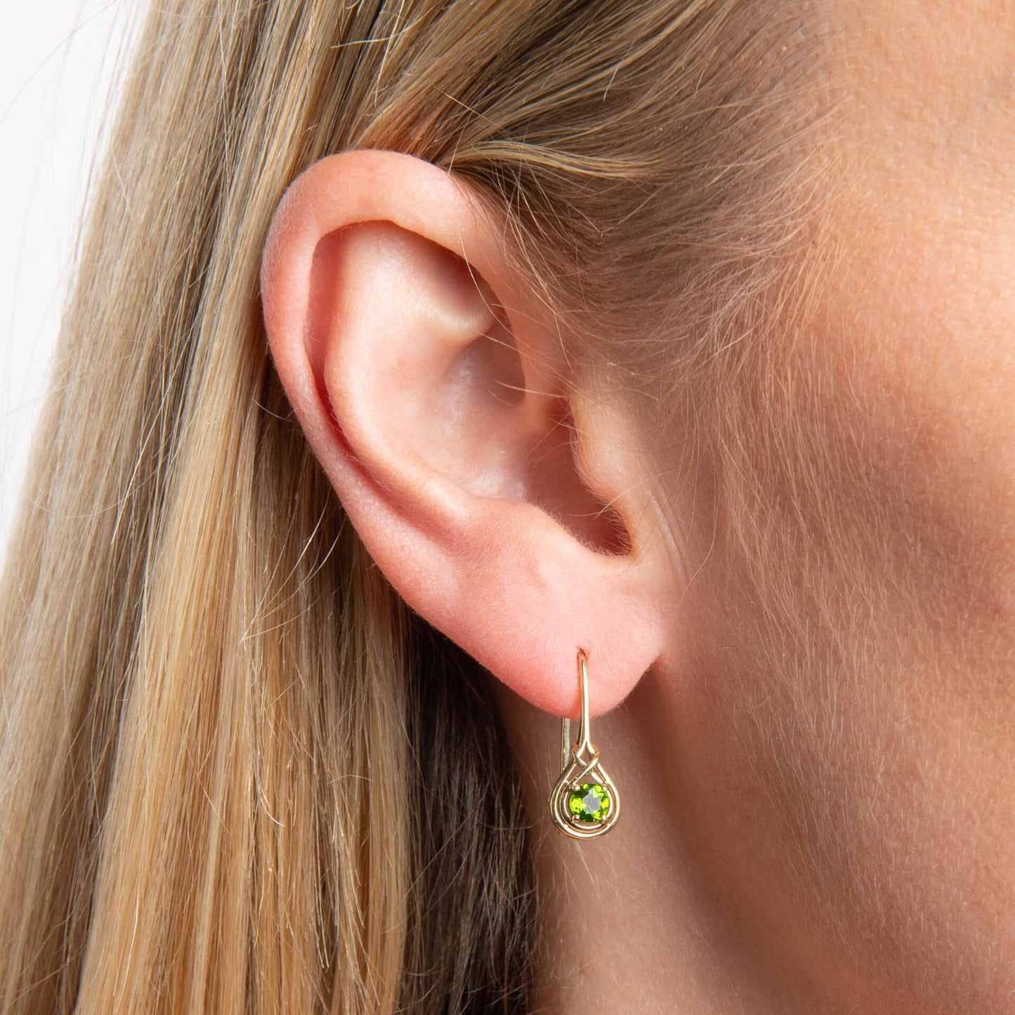 close up of ear wearing up close woman wearing 9ct Gold Celtic Chrome Diopside drop hook earring on white background 
