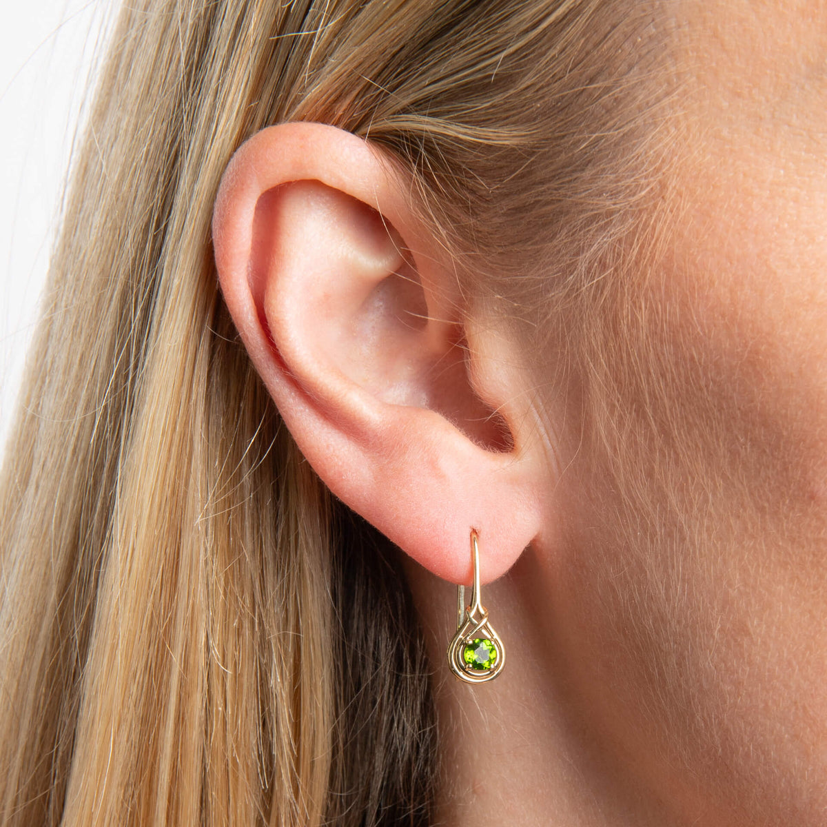 close up of ear wearing up close woman wearing 9ct Gold Celtic Chrome Diopside drop hook earring on white background 