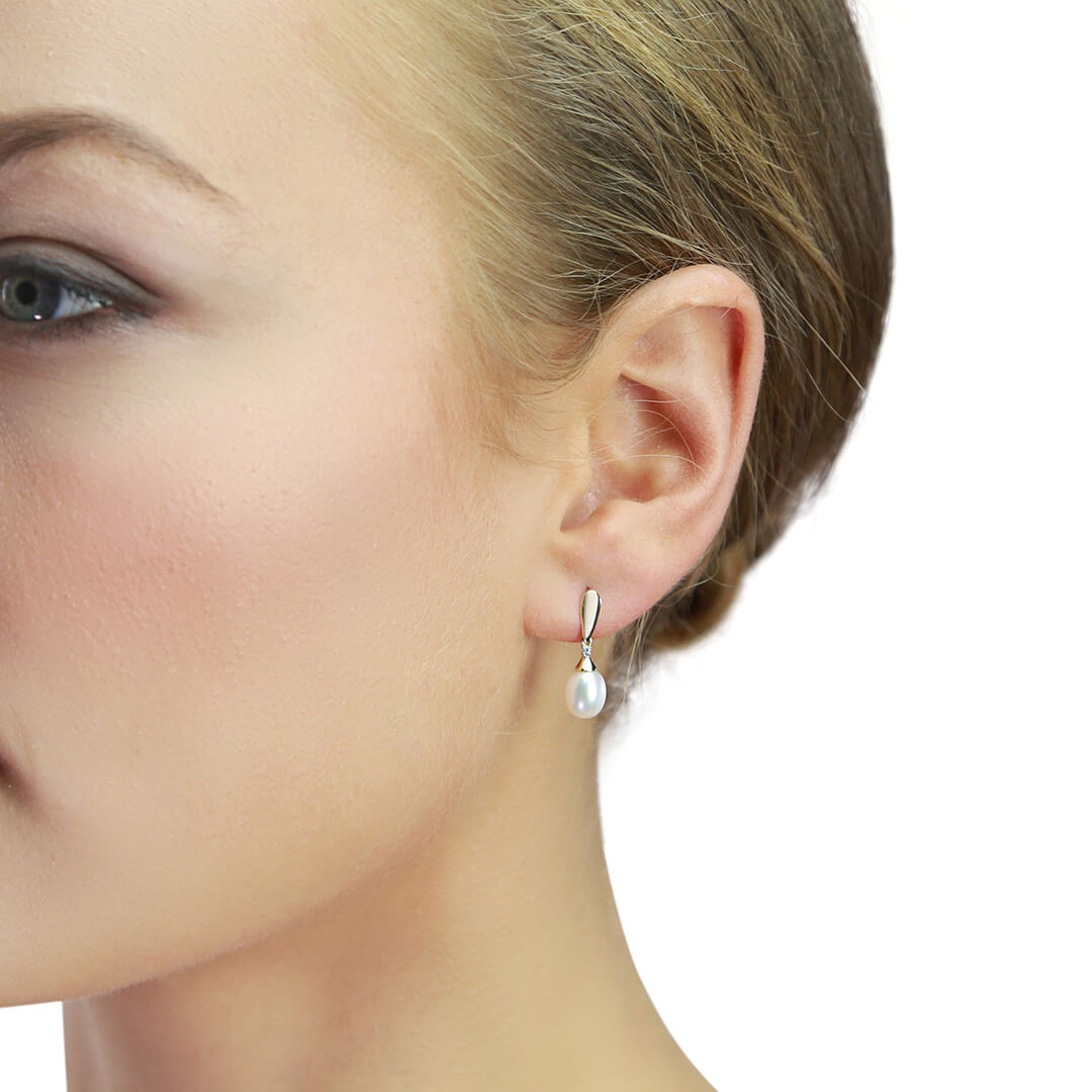 close up of woman ear wearing Gold Freshwater Pearl & Diamond Drop Earrings 