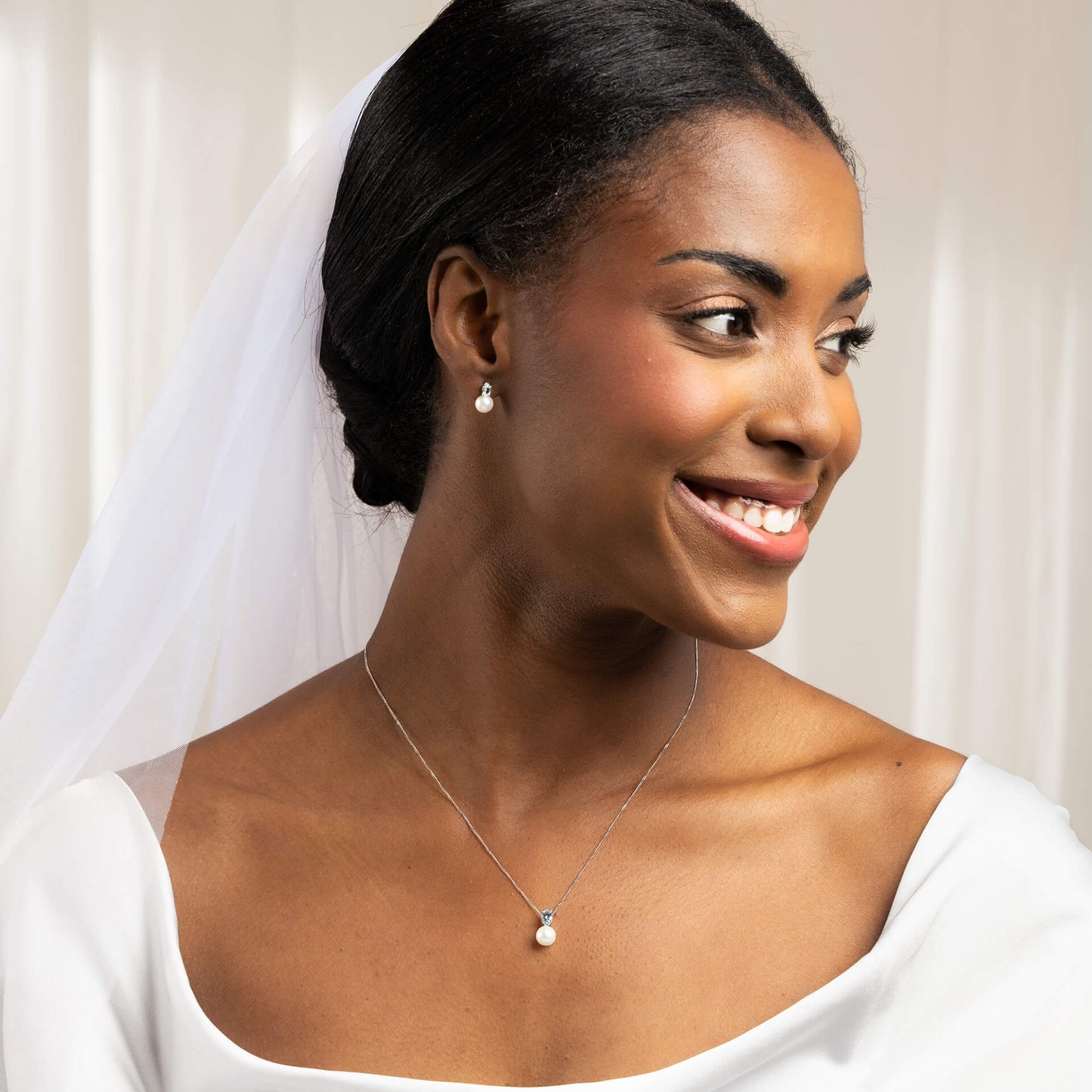 close up woman dressed as bride wearing  9ct Gold Freshwater Pearl & Sky Blue Topaz Pendant necklace and earrings set 
