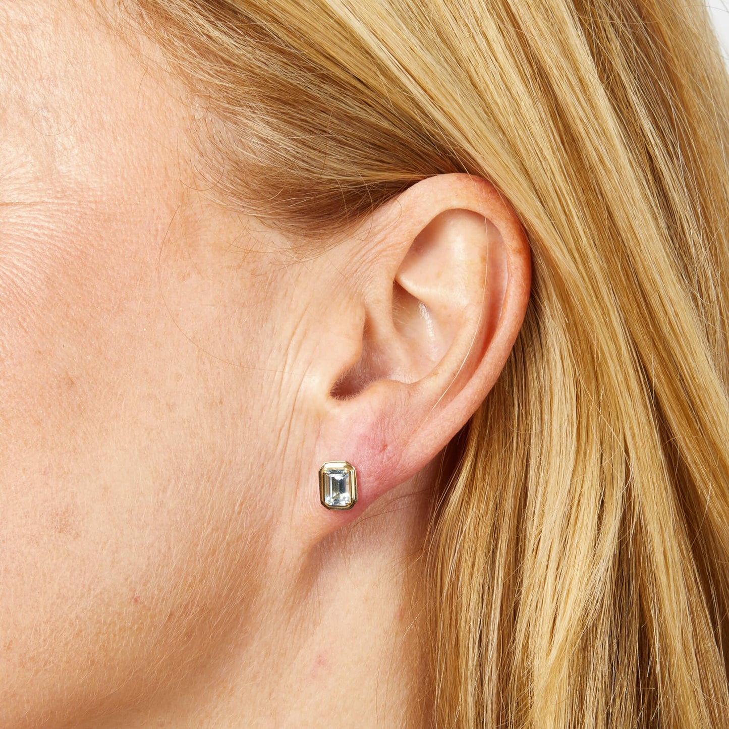 close up woman ear wearing Elongated Octagon Aquamarine Gold Stud Earrings 