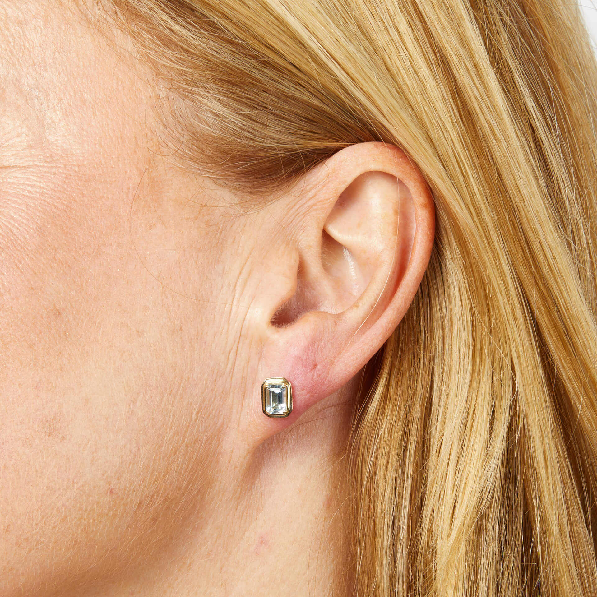 close up woman ear wearing Elongated Octagon Aquamarine Gold Stud Earrings 