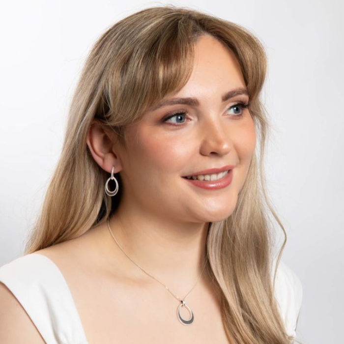 model wearing Open Tear drop silver Earrings with Mille grain Edge with necklace on white background 