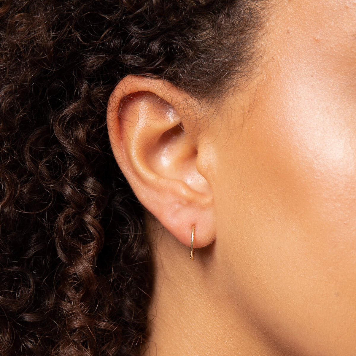 ear close up wearing gold slim hoop earring