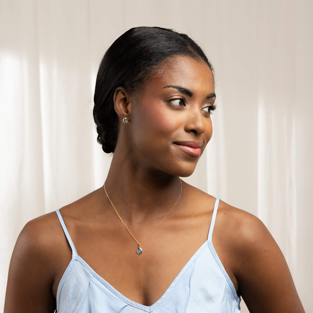 from far woman 9ct Gold Australian Blue Opal Doublet Teardrop Stud Earrings and necklace set with blue v neck spaghetti strap top