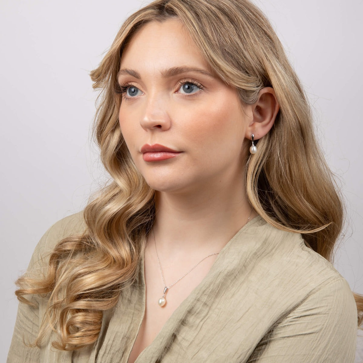 from far woman wearing 9ct Gold Freshwater Pearl & Diamond Drop Earrings and necklace set