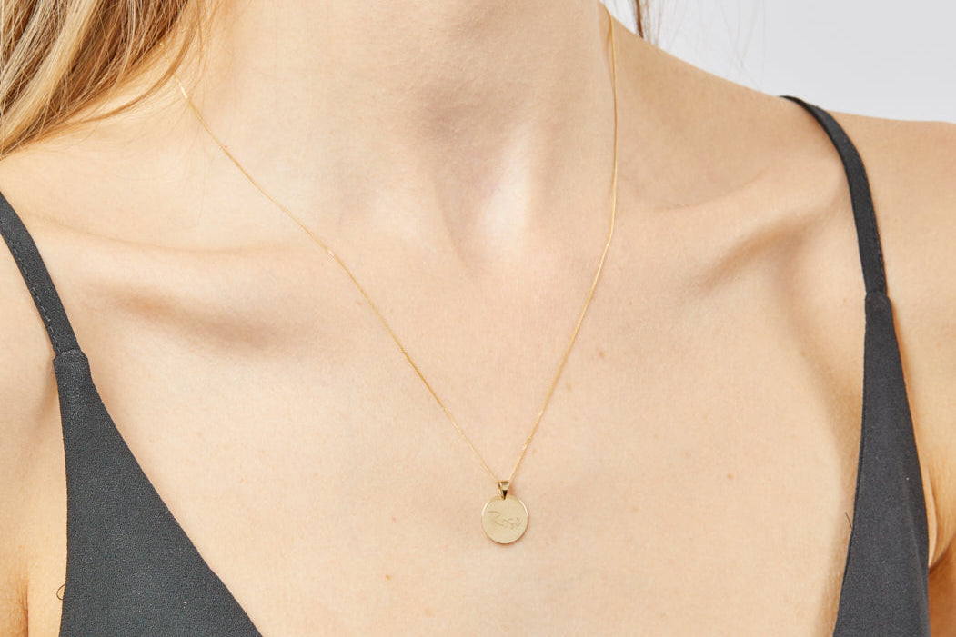 model wearing 9ct gold engravable round pendant necklace