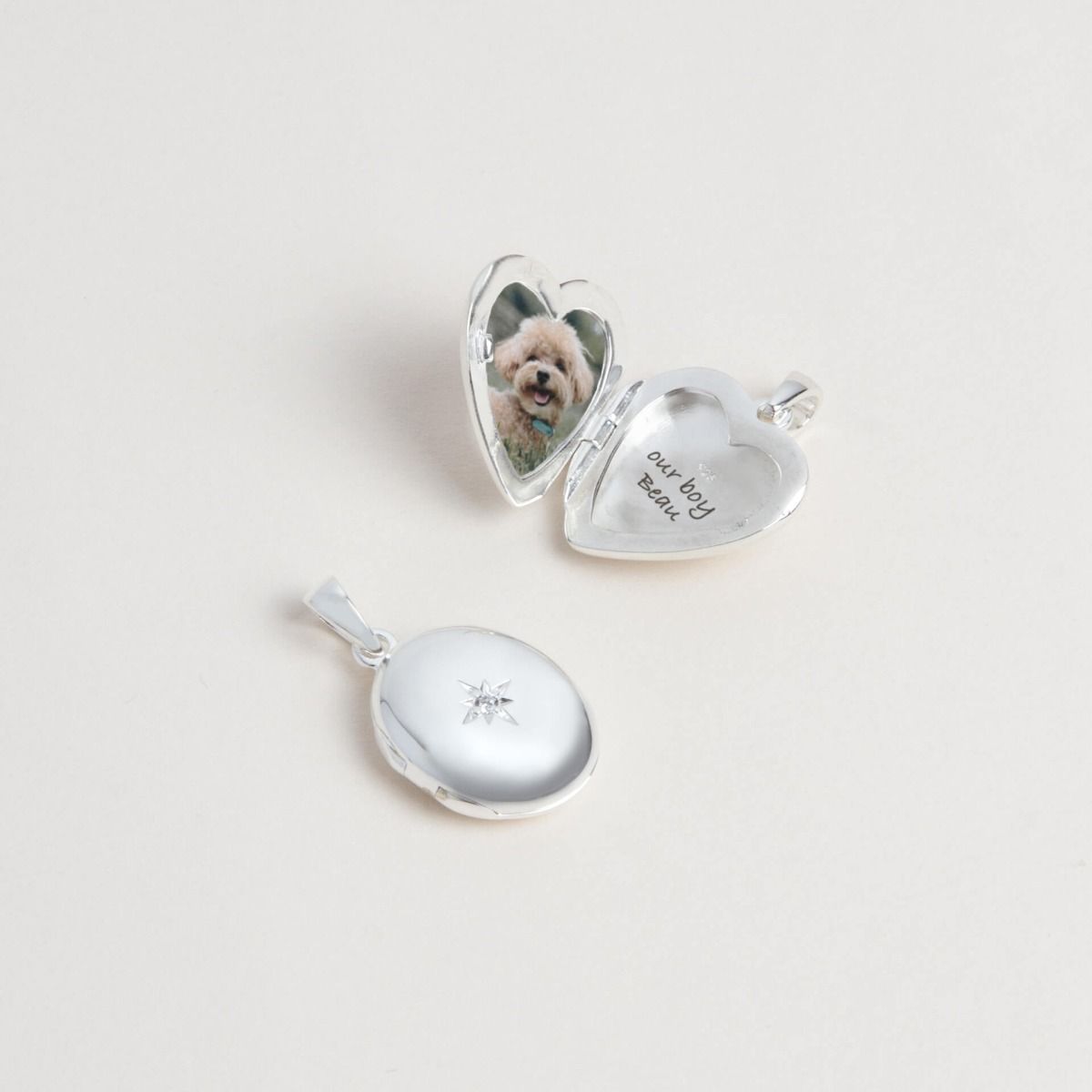 Heart-shaped silver locket open with a photo of a dog inside on a light gray background