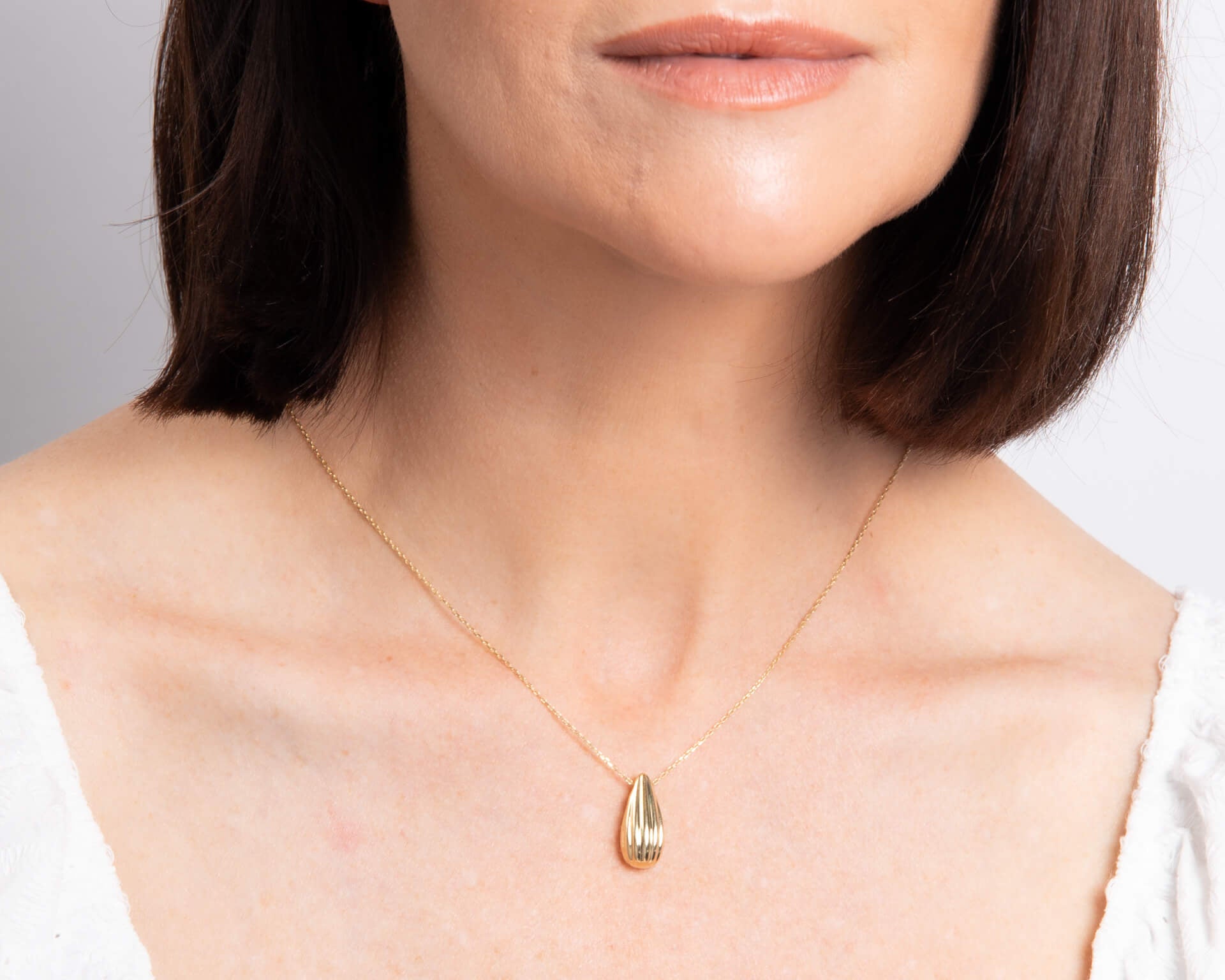 woman wearing Gold Ridged Teardrop Necklace